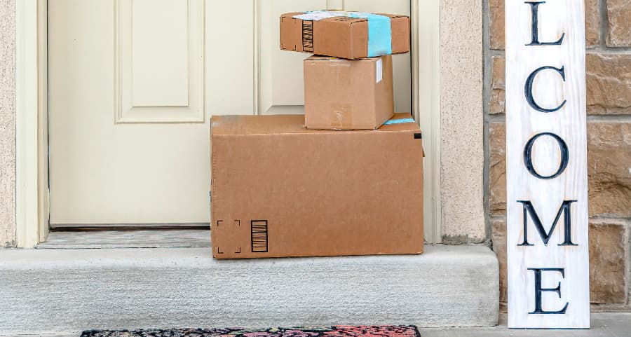 Packages on the doorstep of a home with a welcome sign in Port St. Lucie